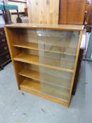 A SET OF THREE TEAK BOOKCASES, ALL WITH GLASS SLIDING DOORS, ENCLOSING THREE SHELVES (3)