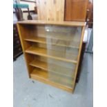 A SET OF THREE TEAK BOOKCASES, ALL WITH GLASS SLIDING DOORS, ENCLOSING THREE SHELVES (3)