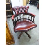 A REPRODUCTION CAPTAIN'S CHAIR, WITH RED HIDE UPHOLSTERY, ON OUTSWEPT SUPPORTS