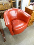 A CRIMSON HIDE TUB SHAPED LOUNGE CHAIR, REVOLVING ON A CONCEALED CIRCUALR BASE