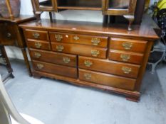 A REPRODUCTION MAHOGANY LARGE CHEST OF DRAWERS/SIDEBOARD, HAVING FOUR SHORT EITHER SIDE OF TWO