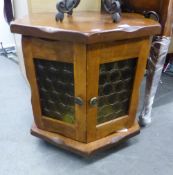 A TEAK WOOD HEXAGONAL LOW OCCASIONAL TABLE OR SMALL CUPBOARD WITH TWO GLAZED DOORS