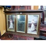 AN OAK FRAMED OVERMANTEL WITH TWO PICTURES OF LADIES, EACH SIDE OF A CENTRAL MIRROR