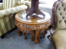 A MODERN CHINESE HARDWOOD NEST OF CIRCULAR TABLES CARVED IN HIGH RELIEF; THE TOP DEPICTING FIGURES