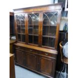 A REPRODUCTION BOOKCASE, GLAZED UPPER PORTION WITH DRAWERS AND CUPBOARDS UNDER