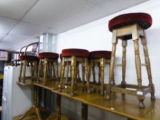 A SET OF EIGHT LOW BAR STOOLS, WITH RED FABRIC SEATS AND A MATCHING TALLER STOOL (9)