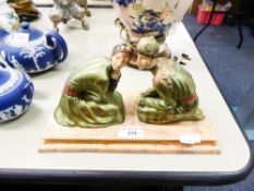 A MODERN ART DECO STYLE FIGURE GROUP, TWO DANCING FIGURES KNEELING, IN GREEN ATTIRE, ON VEINED BASE