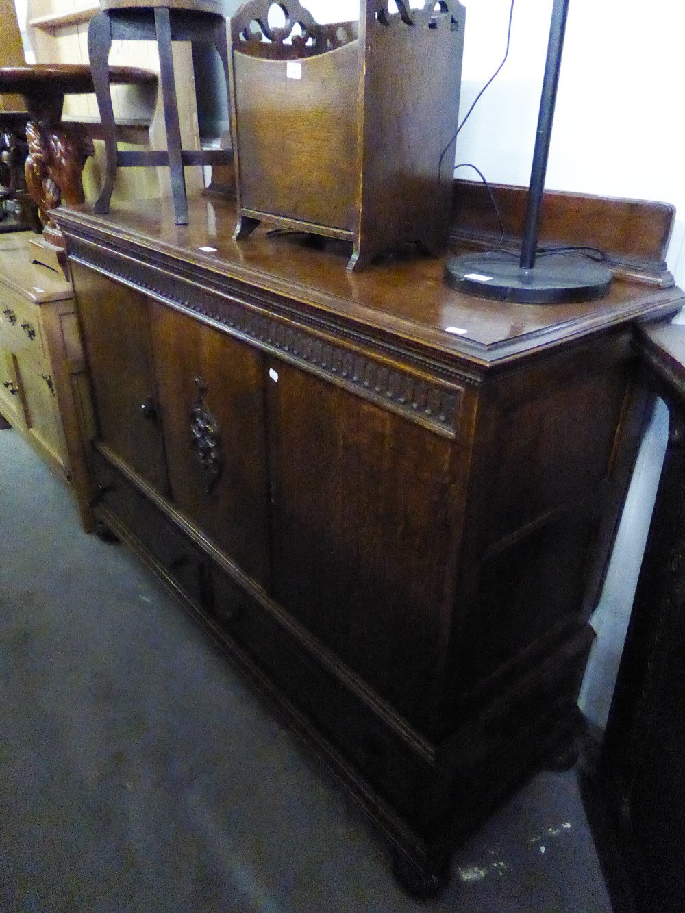 A 1930's OAK SIDEBOARD WITH THREE DOORS ABOVE THREE DRAWERS, WITH FITTED INTERIOR DRAWERS AND LOW