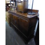 A 1930's OAK SIDEBOARD WITH THREE DOORS ABOVE THREE DRAWERS, WITH FITTED INTERIOR DRAWERS AND LOW