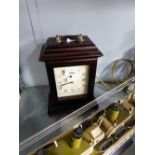 A MAHOGANY BRACKET CLOCK WITH BRASS CARRYING HANDLE WITH QUARTZ MOVEMENT