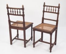 A SET OF FIVE EARLY 1900's OAK SINGLE DINING CHAIRS, with spindled backs and cane seats, on turned