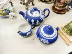 A WEDGWOOD JASPERWARE BLUE TEAPOT, MILK JUG AND A SUGAR BOWL (3)