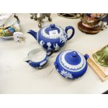 A WEDGWOOD JASPERWARE BLUE TEAPOT, MILK JUG AND A SUGAR BOWL (3)