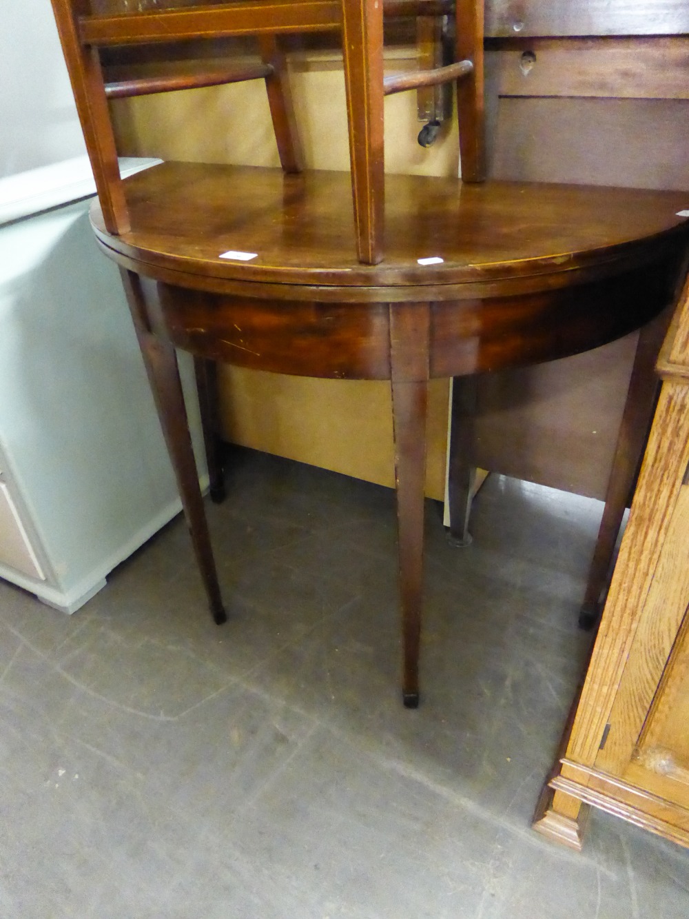 EARLY NINETEENTH CENTURY LINE INLAID MAHOGANY DEMI-LUNE FOLD OVER TEA TABLE, raised on square,