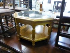 A LIGHTWOOD OCTAGONAL COFFEE TABLE WITH GLASS TOP AND A SOLID UNDERSHELF