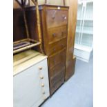 AN OAK TALL NARROW CHEST OF SEVEN DRAWERS