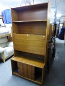 A TEAK NARROW WALL UNIT WITH DROP-FRONT SECTION TO THE TOP AND SLIDING DOORS BELOW