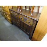 A MID TWENTIETH CENTURY DARK OAK SIDEBOARD, HAVING TWO DRAWERS OVER TWO DOOR CUPBOARD