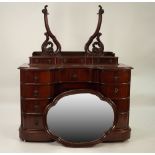 LATE VICTORIAN MAHOGANY INVERTED BREAKFRONT DRESSING CHEST, the shaped oval mirror in a moulded