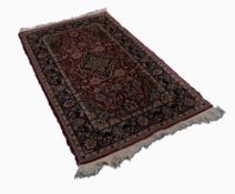 PERSIAN RUG, with midnight blue and floral lozenge shaped centre medallion on a red and Herati