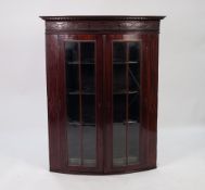 GEORGIAN LINE INLAID MAHOGANY BOW FRONTED AND GLAZED CORNER CUPBOARD, the moulded cornice above a