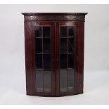 GEORGIAN LINE INLAID MAHOGANY BOW FRONTED AND GLAZED CORNER CUPBOARD, the moulded cornice above a