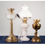 THREE EDWARDIAN OIL TABLE LAMPS, comprising: two in brass with etched glass shades, the other in