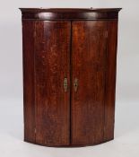 GEORGE III LINE INLAID OAK AND MAHOGANY BOW FRONTED CORNER CUPBOARD, of typical form with embossed