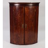 GEORGE III LINE INLAID OAK AND MAHOGANY BOW FRONTED CORNER CUPBOARD, of typical form with embossed