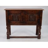 JACOBEAN STYLE CARVED AND DISTRESSED LIGHT OAK SIDE CABINET, the oblong top above a pair of panelled