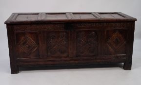 SEVENTEENTH CENTURY CARVED OAK COFFER, the four panelled, hinged top above a scroll carved frieze,