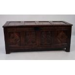 SEVENTEENTH CENTURY CARVED OAK COFFER, the four panelled, hinged top above a scroll carved frieze,