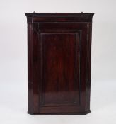 GEORGE III MAHOGANY FLAT FRONTED CORNER CUPBOARD, the moulded cornice above a crossbanded and