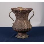 MIDDLE EASTERN PIERCED AND CHASED COPPER TWO HANDLED VASE, of waisted form with flared, wavy rim,