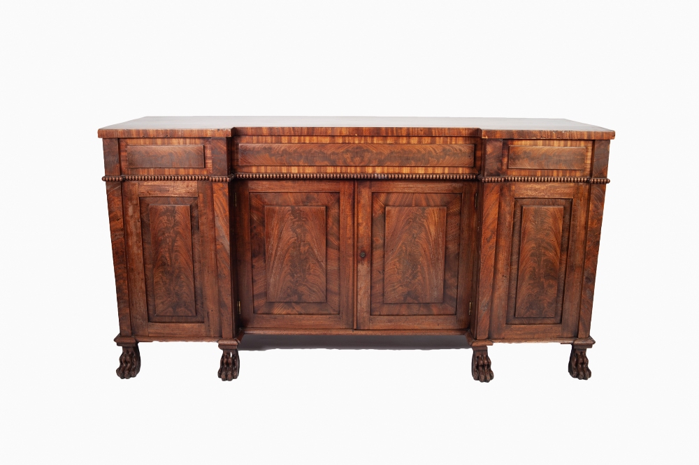 WILLIAM IV FIGURED MAHOGANY INVERTED BREAKFRONT SIDEBOARD, the shaped, crossbanded top above a