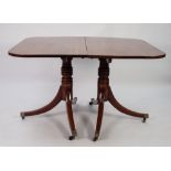 LATE GEORGIAN TWIN PILLAR MAHOGANY DINING TABLE WITH EXTRA LEAF, the rounded oblong top above a pair