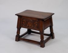 MODERN REPRODUCTION CARVED MEDIUM OAK BOX STOOL, the hinged oblong top above a deep front panel