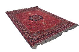 AN ATTRACTIVE SEMI-ANTIQUE TURKISTANI WOOL PILE CARPET, overall predominately red and indigo, the