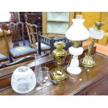 THREE EDWARDIAN OIL TABLE LAMPS, comprising: two in brass one with etched glass shade, the other