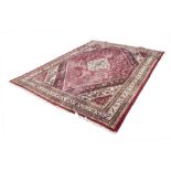 EASTERN CARPET, with diamond shaped white medallion with pendants on a red and herati field with