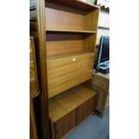A TEAK NARROW WALL UNIT WITH DROP-FRONT SECTION TO THE TOP AND SLIDING DOORS BELOW