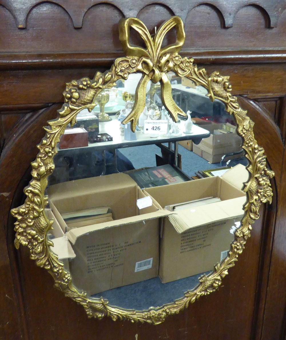 A GILT EDGED OVAL WALL MIRROR