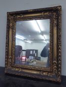 AN EARLY CENTURY GILT GESSO FRAMED WALL MIRROR, 54cm wide x 63cm high