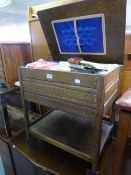 AN OAK SEWING/WORK TROLLEY WITH LIFT-UP TOP AND DRAWER BELOW AND UNDERPLATFORM AND THE CONTENTS OF