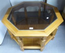 A LIGHTWOOD OCTAGONAL COFFEE TABLE WITH GLASS TOP AND SOLID UNDER SHELF