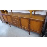 A G-PLAN DARK TEA SIDEBOARD, HAVING TWO END CUPBOARDS AND FOUR CENTRAL DRAWERS ON SHAPED SUPPORTS