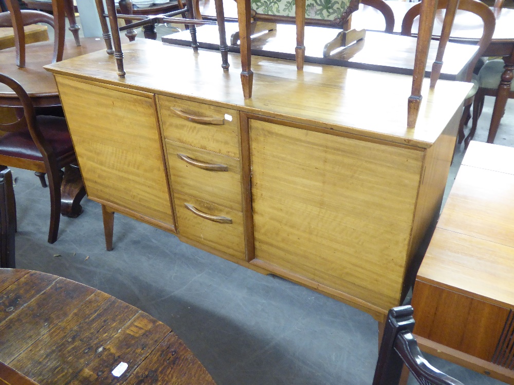 A TEAK SIDEBOARD OF FOUR CENTRAL DRAWERS, FLANKED BY CUPBOARDS TO EACH SIDE ON SPLAYED LEGS