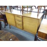 A TEAK SIDEBOARD OF FOUR CENTRAL DRAWERS, FLANKED BY CUPBOARDS TO EACH SIDE ON SPLAYED LEGS