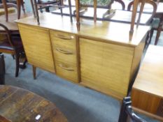 A TEAK SIDEBOARD OF FOUR CENTRAL DRAWERS, FLANKED BY CUPBOARDS TO EACH SIDE ON SPLAYED LEGS