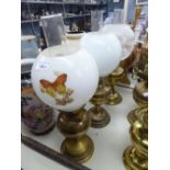 THREE EARLY/MID 20TH CENTURY BRASS OIL LAMPS WITH CLEAR GLASS FUNNELS AND TWO HAVING WHITE GLOBE